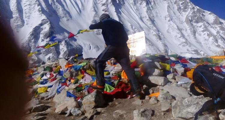 Personne accrochant des drapeaux de prière dans les montagnes.