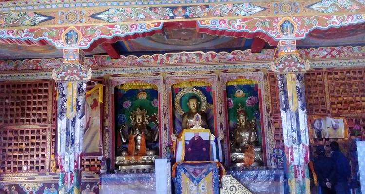 Interieurzicht van een rijkelijk versierde tempel met godheidsfiguren.