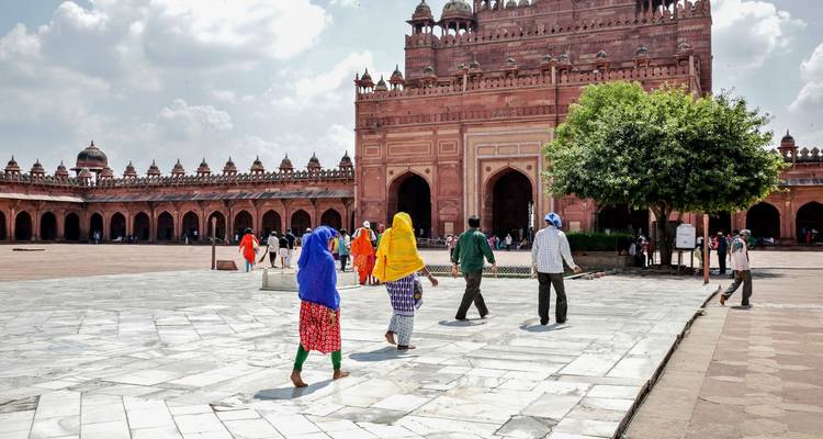 Eine Gruppe von Menschen, die auf ein großes, prunkvolles Gebäude zugeht.