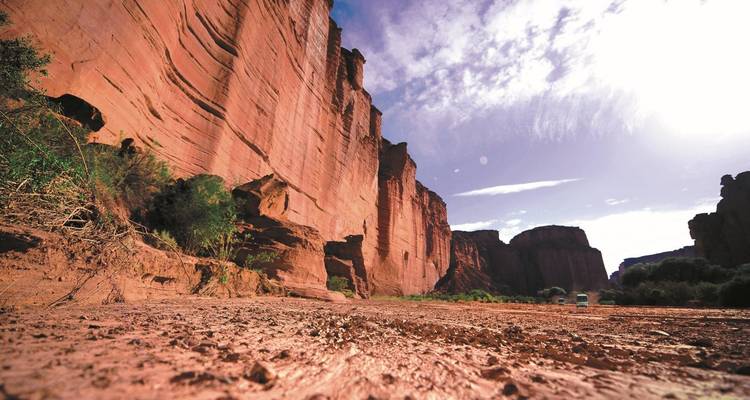 Red rock cliffs under a partly cloudy sky.