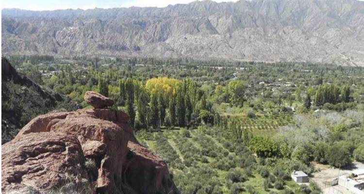 Valley landscape with farms and mountains.