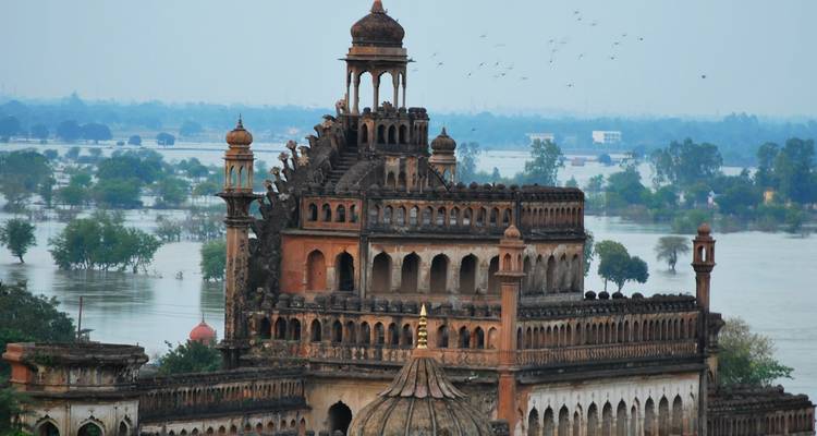 Historisch gebouw met uitzicht over water en groen.