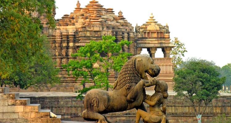 Standbeeld van een leeuw met een tempel op de achtergrond op een oude archeologische site.
