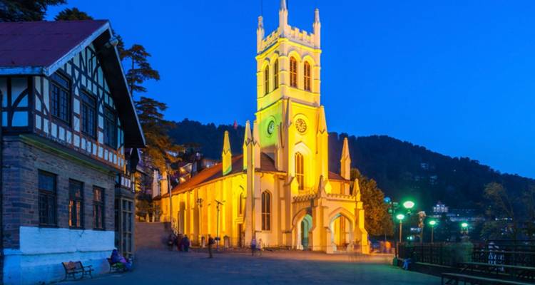 Verlichte kerk in de schemering met een blauwe lucht op de achtergrond.