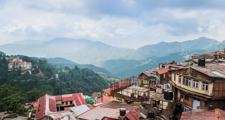 Bergstadje met bergen op de achtergrond onder bewolkte luchten.