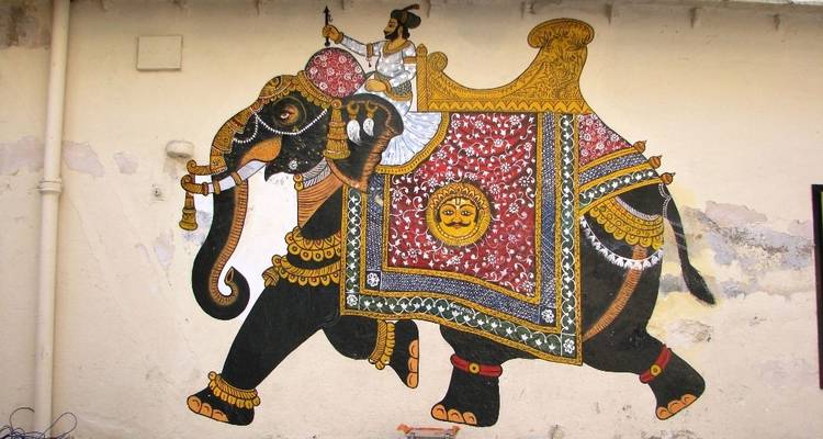 Farbenfrohe Wandmalerei eines geschmückten Elefanten.