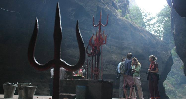 Gruppe in einer Höhle mit religiösen Artefakten.