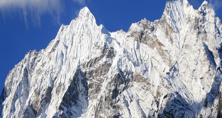 Schneebedeckte Bergkette mit klarem blauem Himmel im Hintergrund.