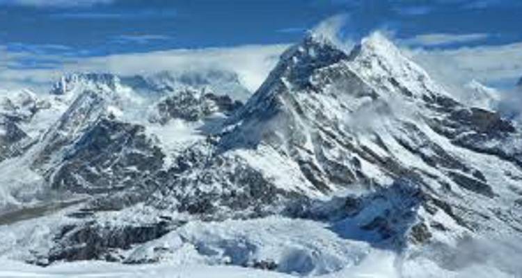 Berggipfel, die mit Schnee bedeckt und von Wolken umgeben sind.