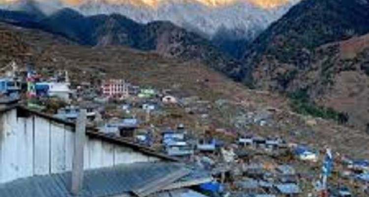 Een bergdorp met talloze kleine huisjes en besneeuwde toppen op de achtergrond.