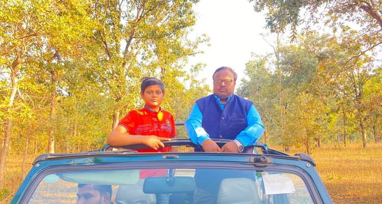 Twee mensen die in een voertuig staan in een bosgebied.