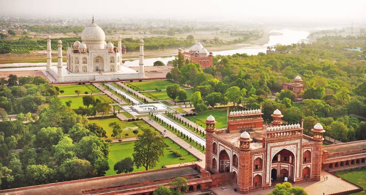 Luchtfoto van de Taj Mahal met omringende tuinen en een rivier.