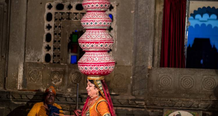 Mujer realizando un acto tradicional de equilibrio con ollas.