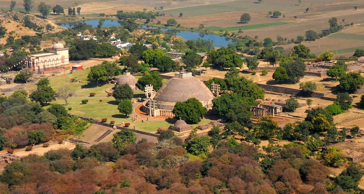 Luftaufnahme eines großen Stupa-Komplexes, umgeben von Bäumen.