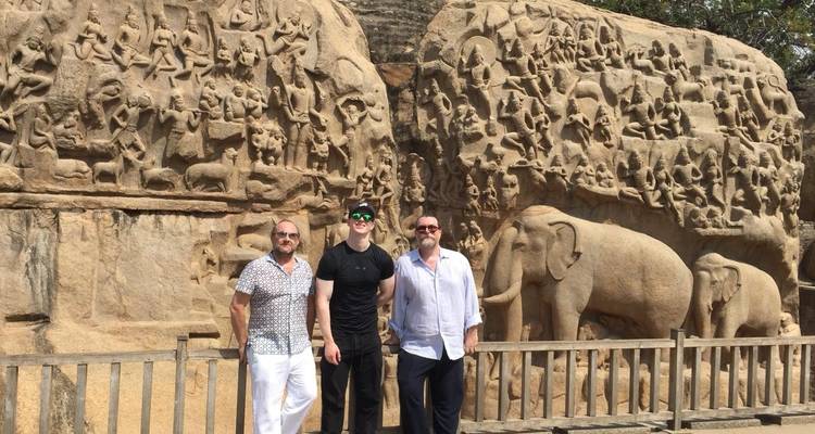 Männer, die neben detaillierten Steinmetzarbeiten stehen.