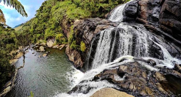 Ein Fluss, der über Felsen in einer üppigen Umgebung hinabstürzt.