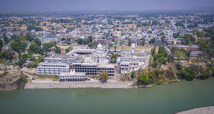 Aerial view of a city with a large complex and a river.