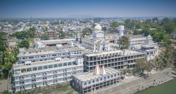Aerial view of a white temple within a cityscape.
