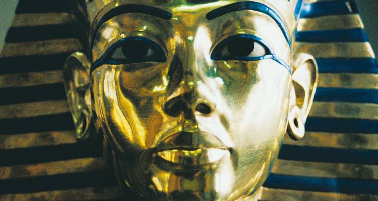 Gleaming golden funerary mask of Tutankhamun with inlaid blue stripes fills the frame.