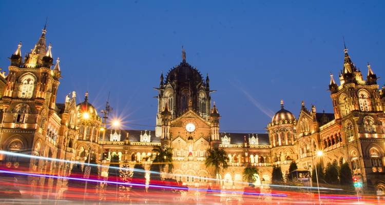 Verlicht stationsgebouw 's nachts met lichtsporen