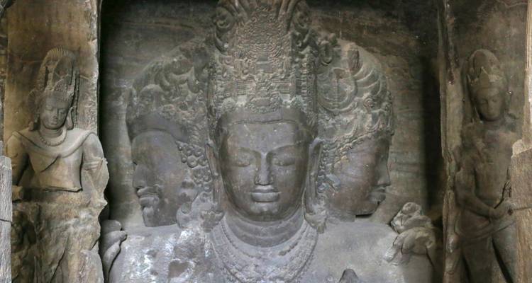 Oud stenen beeldhouwwerk met meerdere gezichten