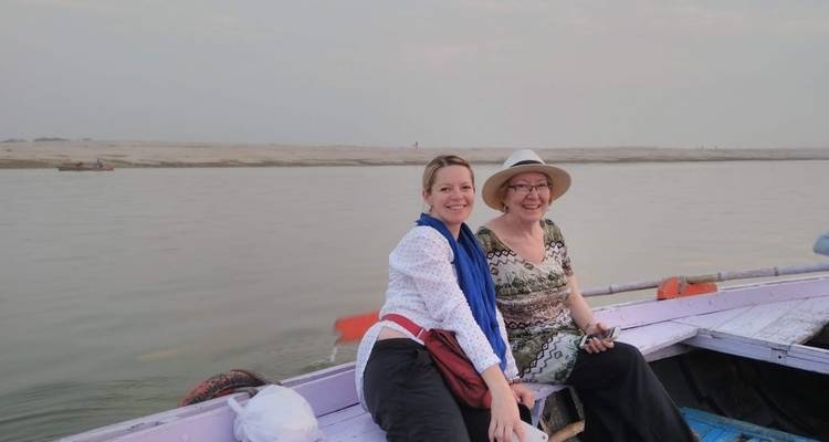 Deux femmes assises sur un bateau sur une rivière calme.