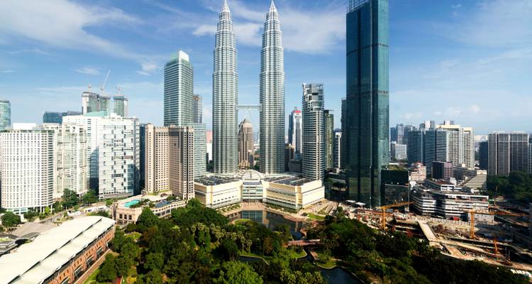 El horizonte de Kuala Lumpur dominado por las Torres Gemelas Petronas contra un cielo azul despejado.
