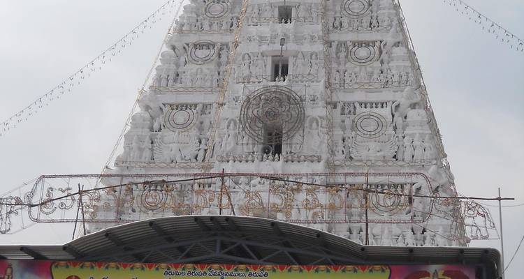 Nahaufnahme eines Tempelturms, der mit weißen Schnitzereien verziert ist.