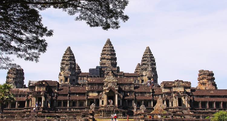 Templo de Angkor Wat en Camboya con turistas y un cielo despejado.