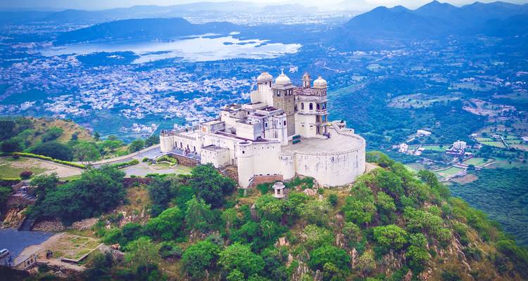 Luftaufnahme einer Bergfestung mit einem See und einer Stadt darunter.