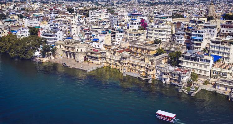 Alte Stadtgebäude entlang der Uferpromenade mit einem Boot auf dem Wasser.