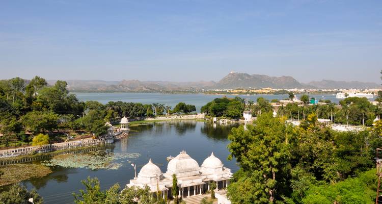 Een schilderachtig uitzicht op een meer met heuvels op de achtergrond in Udaipur.
