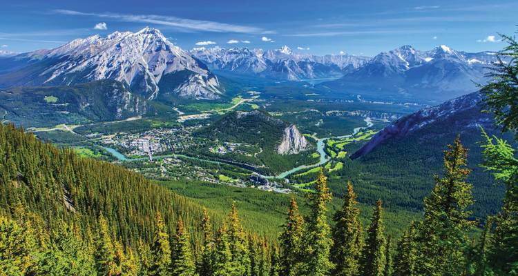 Weids luchtfoto over het Banff dorpscentrum genesteld tussen dramatische Rocky Mountains en kronkelende rivier.
