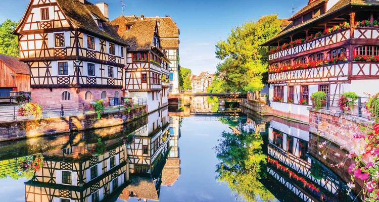 Des maisons à colombages charmantes reflétées dans un canal tranquille du quartier historique de la Petite France