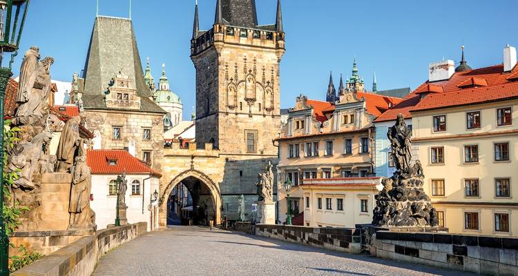 Le pont Charles historique bordé de statues menant aux tours de la Vieille Ville sous un ciel matinal dégagé à Prague