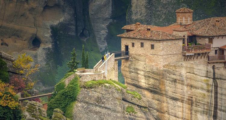 Monastère de pierre sur une falaise avec une connexion par pont.