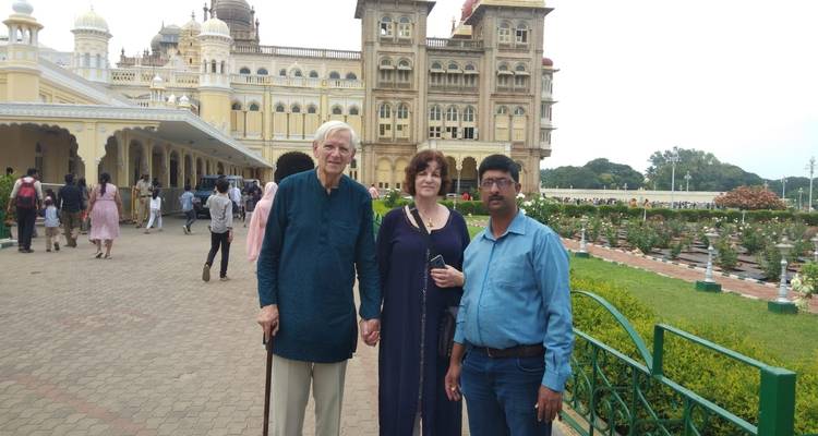 Three people standing outside Mysore Palace.