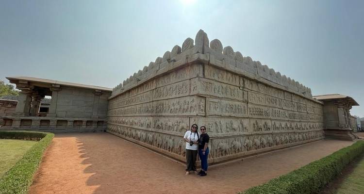 Two people in front of stone temple.