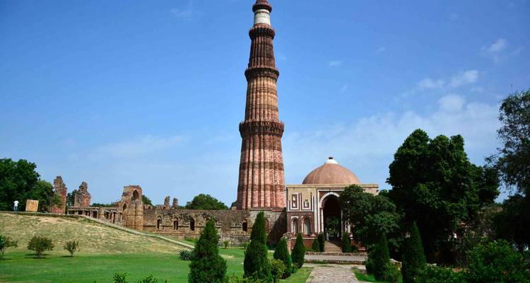 Hoge toren en koepelgebouw met tuinen.