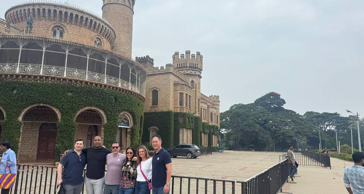 Gruppe von Menschen, die vor einem historischen Schloss mit efeubedeckten Mauern posiert.