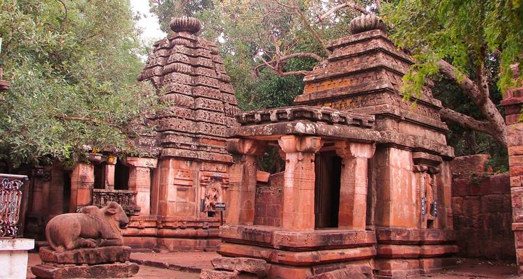 Ancient stone temple with two towers and a statue of a bull.
