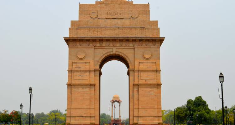 India Gate monument in New Delhi met een heldere lucht en weelderige omgeving.
