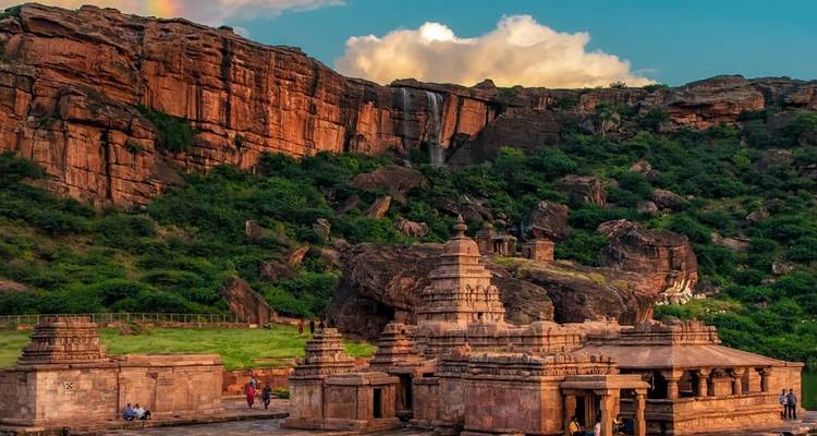 Oude tempels tegen een dramatische klif met waterval.