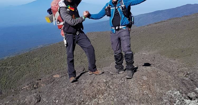 Dos personas posando en un paisaje rocoso con mochilas y equipo de senderismo.