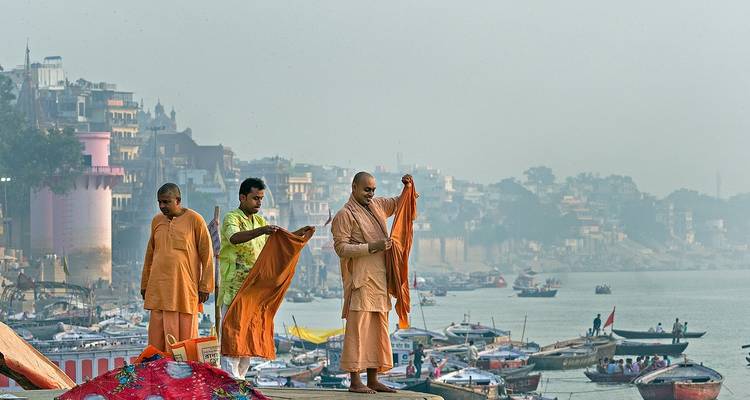 Monks by a river, preparing garments.