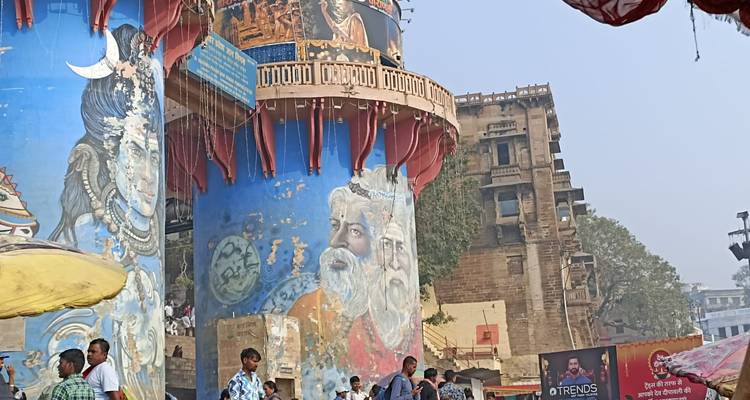Painted blue towers with religious murals and people on a busy street