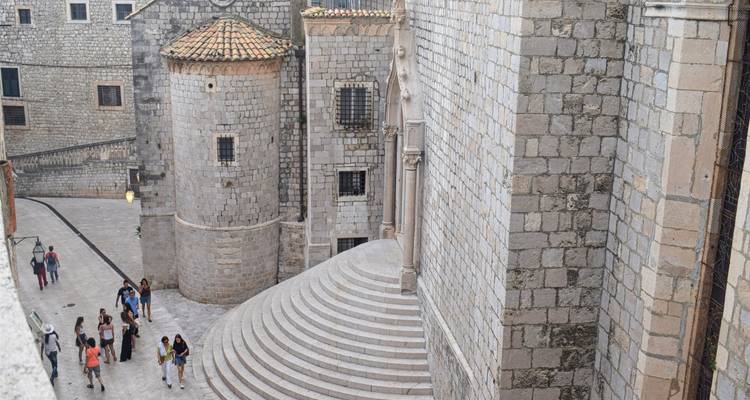 Menschen, die durch einen Steinweg in Dubrovnik gehen.