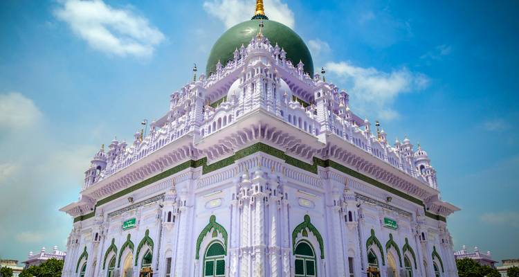 Helgekleurd koepelgebouw met gedetailleerde gravures.