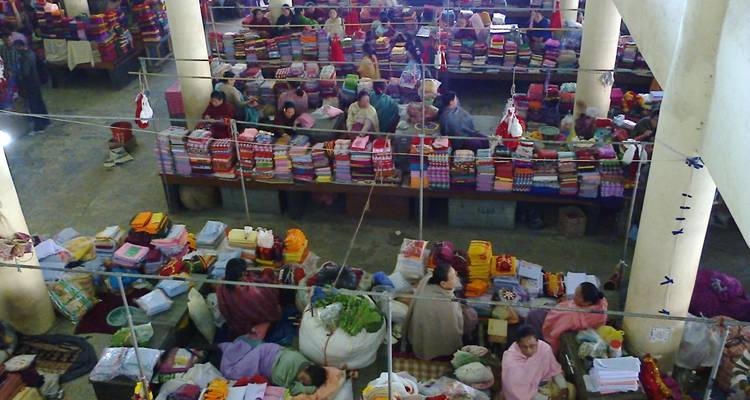 Overdekte markt met talrijke kramen en uitgestalde goederen.