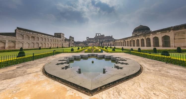 Historische structuur en tuinen met bewolkte lucht.